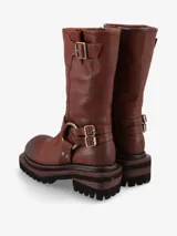 Bota de cuero negro de inspiración biker con caña media. Presenta un diseño robusto con correas ajustables, hebillas metálicas y una argolla decorativa con tachas en el tobillo. Posee suela track de goma para mayor tracción y estabilidad.