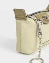 Monedero color verde claro de tela deportiva con solapa con broche con botón, cierre superior con mosquetón y tag en relieve.