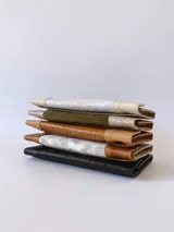 Billetera de cuero color naranja y marrón con cierre de broche y monedero externo.