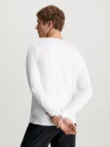 Remera blanca de manga larga Calvin Klein, corte slim, cuello redondo y parche con logo en el pecho.