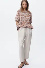 Pantalón tobillero negro con cintura elástica ajustable con cordones, bolsillos delanteros y falsos bolsillos con solapa en la espalda.