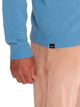 Sweater celeste de punto con cuello alto y cierre frontal completo.