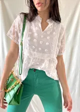 Blusa blanca con detalles bordados y corte suelto, ideal para combinar con prendas de colores.