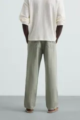 Pantalón color arena de corte recto, confeccionado en tejido de algodón y lino. Cuenta con cintura elástica ajustable con cordón, bolsillos delanteros y traseros de parche.