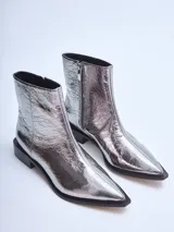 Bota corta plateada de cuero brillante con punta cuadrada y taco bajo negro.