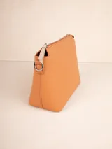Cartera de símil cuero texturizado color naranja, con correa desmontable y regulable, un compartimento principal y tres bolsillos internos adicionales.