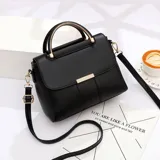 Cartera negra de eco cuero con manijas metálicas doradas y correa larga desmontable.