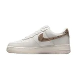 Zapatillas de mujer Nike Air Force 1 07, con parte superior de piel blanca y detalles reflectantes en color rojo.
