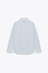 Camisa blanca de popelina de algodón, con cuello solapa y mangas largas con puños abotonados.