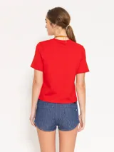 Remera blanca de jersey pesado con escote redondo, mangas cortas y bordado de un ají rojo en el frente.
