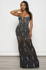 Vestido largo de fiesta negro, corte sirena, con escote en V profundo y breteles finos regulables. Confeccionado en tul elastizado con forro interior y aplique de tul transparente en el escote. Decorado con strass plateados y tornasolados.