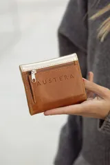 Monedero pequeño de cuero en tonos tostados y plateados, con diseño compacto y cierre de solapa.