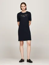 Vestido Tommy Hilfiger azul marino de corte recto y largo a la rodilla, con mangas cortas y cuello redondo. Presenta el logo de la marca bordado en el pecho.