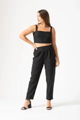 Pantalón palazo negro con cintura elástica, tiro alto y rayas verticales blancas.