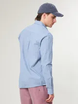 Camisa de vestir a rayas verticales azules y blancas, corte slim fit, con cuello abotonado y logo bordado en el pecho.