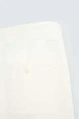 Pantalón chino color crema, de corte recto y largo a la altura del tobillo.