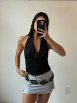 Minifalda negra con brillos, corte ajustado y detalle de nudo en la parte delantera.