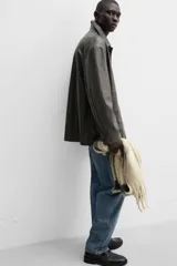 Pantalón de jean gris de corte recto, con cinco bolsillos, efecto lavado y cierre frontal con botones.