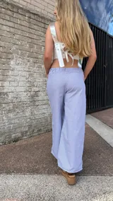 Pantalón largo a rayas verticales azules y blancas, de corte amplio y cintura elástica.