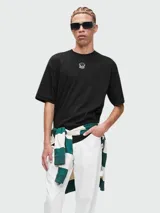 Remera negra de manga corta con cuello redondo y un pequeño logo bordado en el pecho.