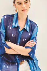 Camisa de seda estampada con diseño batik en tonos azules y blancos, corte amplio y mangas al codo.