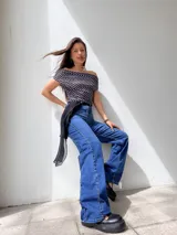 Top negro con lunares blancos, escote off-shoulder y mangas cortas.