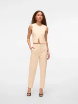 Pantalón color crema con bordado inglés, de corte tapered, tiro alto, cierre de gancho y cremallera, bolsillos delanteros inclinados y bolsillos traseros tipo ojal.