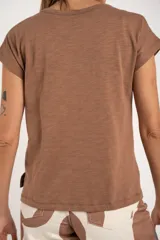 Remera color crudo de algodón peinado con cuello en V y mangas cortas.