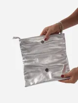 Sobre de fiesta negro charolado con cierre de solapa imantada y tira de cuero para sujetar a la muñeca.