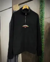 Buzo negro de polar térmico con medio cierre y bordado frontal con montañas y texto "Trial Brand".