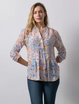 Blusa de gasa estampada con cuello a la base, escote en V y botones. Delantera con detalle plisado y largo de manga regulable con presilla y botón.
