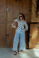 Pantalón de jean celeste de corte ancho, con cintura elástica en la parte trasera y detalles de costuras en los laterales.