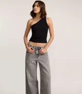 Pantalón skater de jeans con lavado dirty, tiro bajo, trabillas anchas, cierre con botón y cremallera, bolsillos delanteros y traseros, y bolsillo diferenciado.