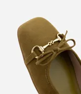 Zapatilla tipo bailarina color verde oliva, con puntera cuadrada, tira sobre el empeine con hebilla metálica y lazo decorativo en la punta.