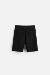 Bermuda negra de corte relaxed fit, con cintura elástica ajustable con cordón, bolsillos frontales y bolsillo trasero de parche.