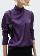 Blusa color violeta de tejido satinado con cuello alto drapeado y mangas largas.