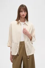 Chaqueta color beige de viscosa con botones, cuello camisero y cordón ajustable en la cintura.