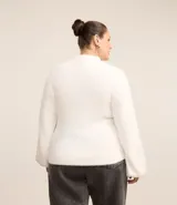 Suéter color beige de punto con textura de pelitos, cuello alto y mangas largas.