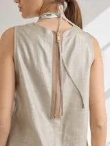 Top color beige de lino y viscosa, corte recto y escote redondo con cierre a la vista en la espalda y pespuntes a contratono.