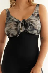 Malla entera combinada con estampado y color negro, con nudo regulable en el escote y bolsillo interno en el busto.