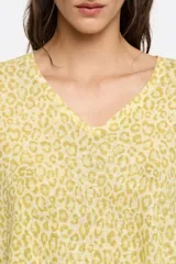 Remera de tejido liviano color amarillo pálido con estampado animal print en tono más oscuro, corte holgado y cuello en V.