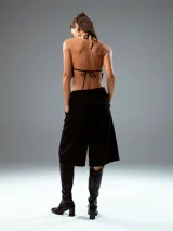Pantalón culotte negro de vestir, con tiro alto, corte ancho y largo a la pantorrilla.