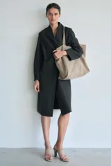 Bolso tipo maxi shopper color beige de ante, con doble asa de hombro y bolsillo interior con cremallera.