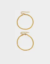 Set de dos pulseras doradas flexibles de acero quirúrgico con cierre de mosquetón y cadena de extensión.