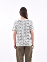 Remera blanca con estampado de ojos y pestañas en negro.