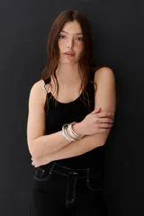 Musculosa blanca con breteles finos y detalle metálico en uno de los breteles.