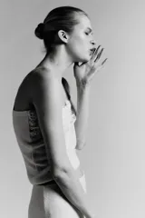 Top de punto color crema claro, corte recto y ajustado, con detalle de encaje floral bordado en el escote. Posee tirantes ajustables de color beige claro.