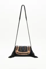 Cartera bandolera negra de cuero con diseño trenzado en el frente y flecos en gamuza. Tiene correa trenzada con terminación y forro de algodón.