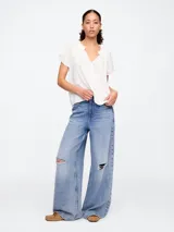 Blusa blanca de manga corta con escote en V y detalle de volados en el cuello.