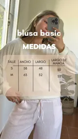 Blusa color crudo de tejido suave, con escote redondo y puños en las mangas.